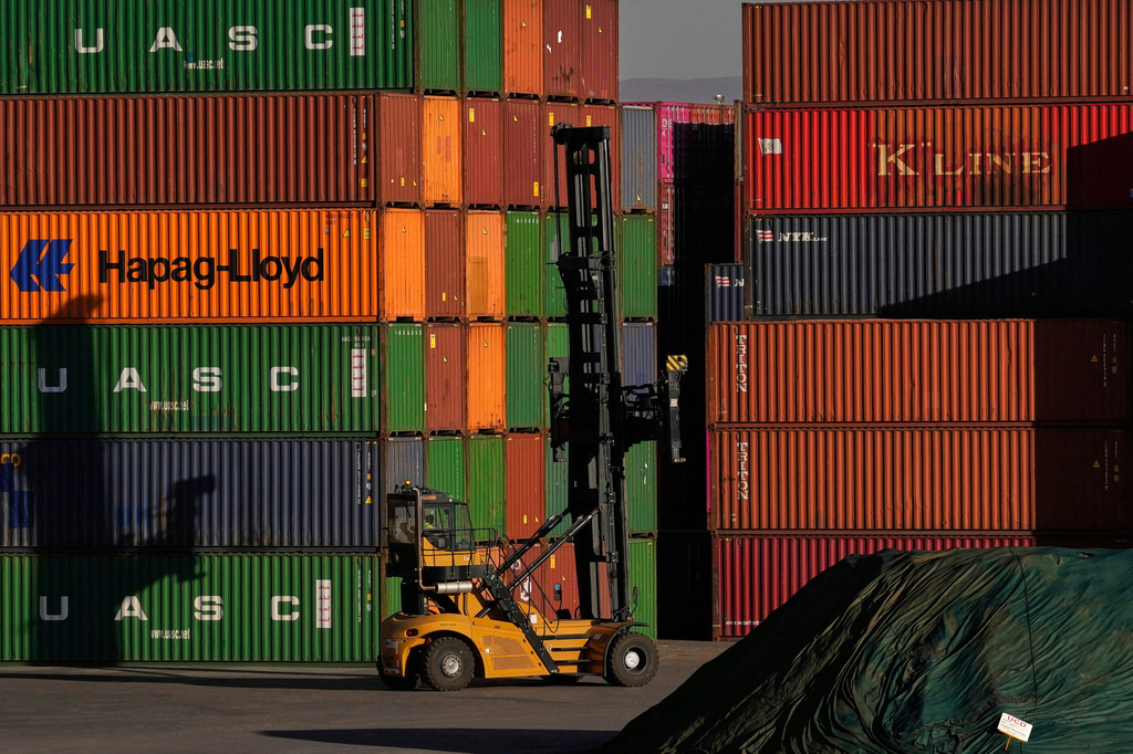 FILE - A heavy machine drives past shipping containers stacked at a depo, in Johannesburg, South Africa, Friday, Aug. 1, 2025. (AP Photo/Themba Hadebe, File)