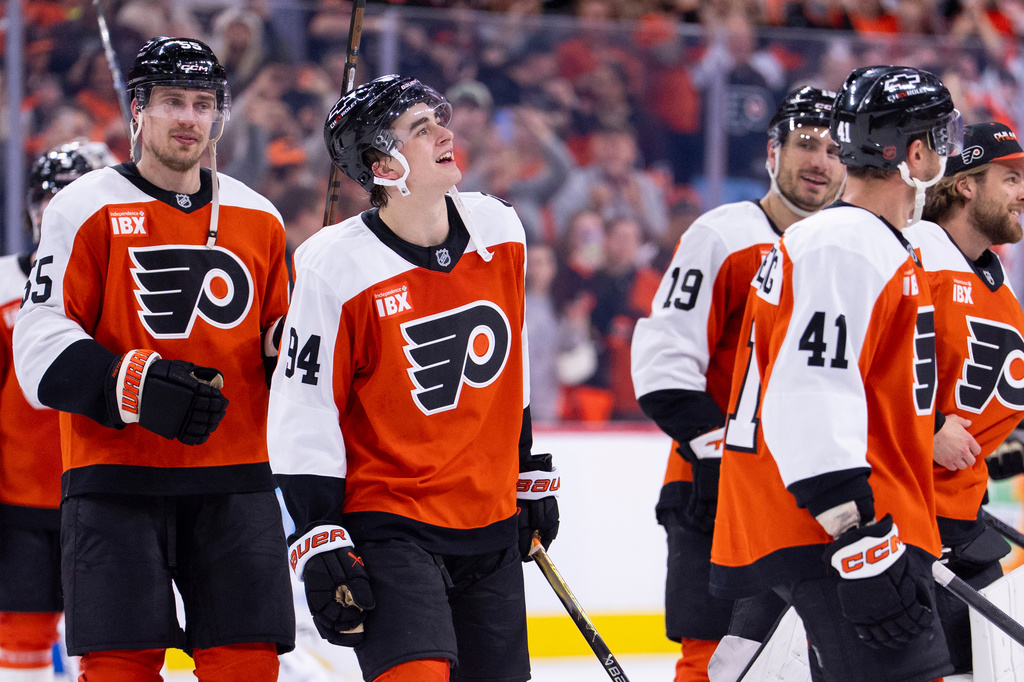 FILE - Philadelphia Flyers right winger Porter Martone, center, looks on as the Flyers celebrate the win and playoff berth after an NHL hockey game against the Carolina Hurricanes, April 13, 2026, in Philadelphia. (AP Photo/Chris Szagola, File)