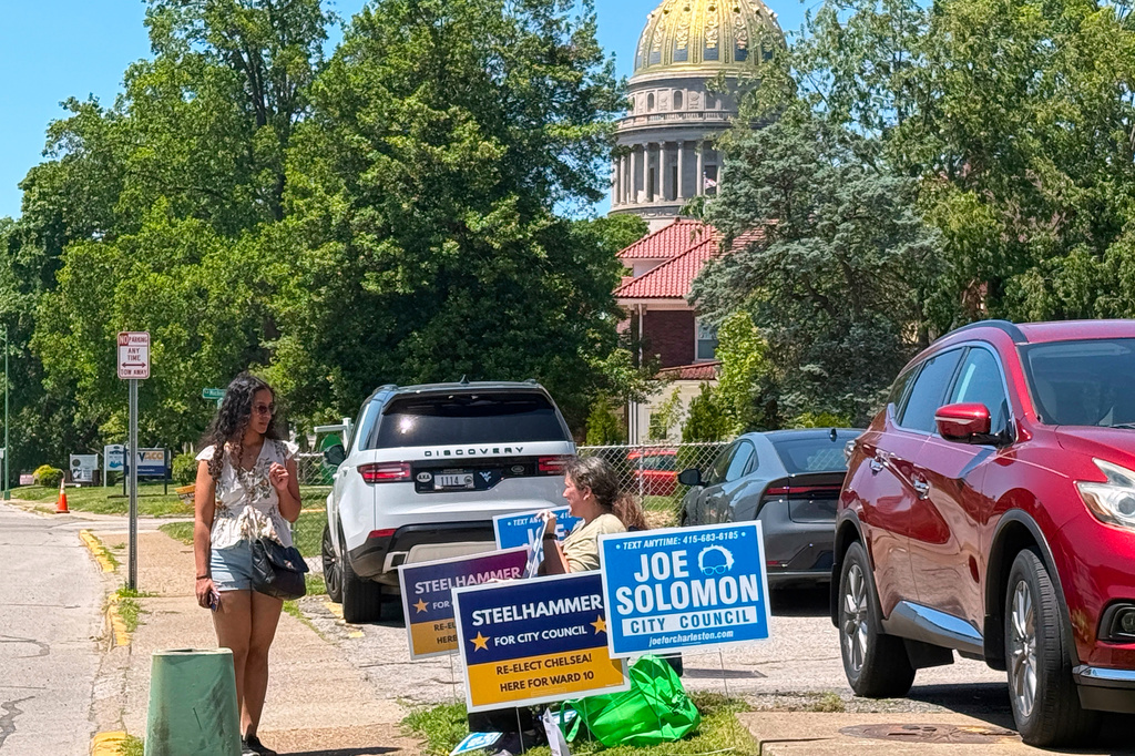 A voter walks past campaign signs near the state Capitol on Tuesday May 12, 2026, in Charleston, W.Va. (AP Photo/John Raby)