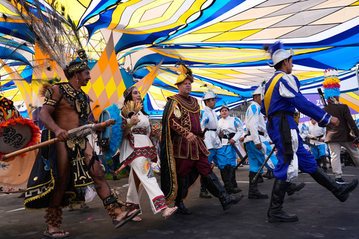 Moctezuma, represented by Gerardo Hernández Espinoza, left, La Malinche, represented by Ximena Isabel Ochoa López, center, and Hernán Cortez, represented by José Antonio Ochoa Lopez take part in a pre-Hispanic dance in the Zocalo, in Mexico City, Sunday, Oct. 12, 2025. (AP Photo/Marco Ugarte) Moctezuma, represented by Gerardo Hernández Espinoza, left, La Malinche, represented by Ximena Isabel Ochoa López, center, and Hernán Cortez, represented by José Antonio Ochoa Lopez take part in a pre-Hispanic dance in the Zocalo, in Mexico City, Sunday, Oct. 12, 2025. (AP Photo/Marco Ugarte)