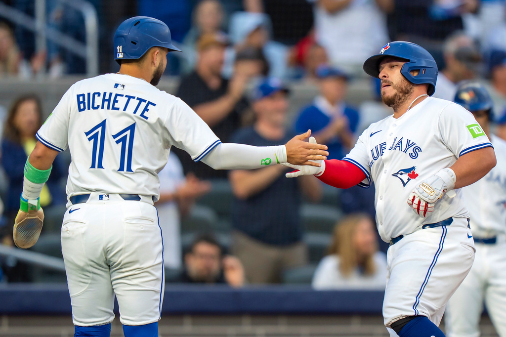 Toronto Blue Jays' Alejandro Kirk, center, is congratulated by Bo Bichette (11) after they scored on his two-run home run in first-inning baseball game action against the Minnesota Twins in Toronto, Monday, Aug. 25, 2025. (Frank Gunn/The Canadian Press via AP)