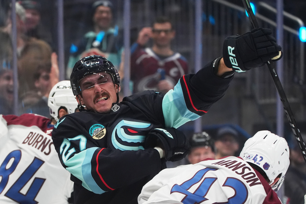 Seattle Kraken left wing Mason Marchment, left, swings at Colorado Avalanche defenseman Josh Manson (42) during a fight during the third period of an NHL hockey game Tuesday, Dec. 16, 2025, in Seattle. (AP Photo/Lindsey Wasson)