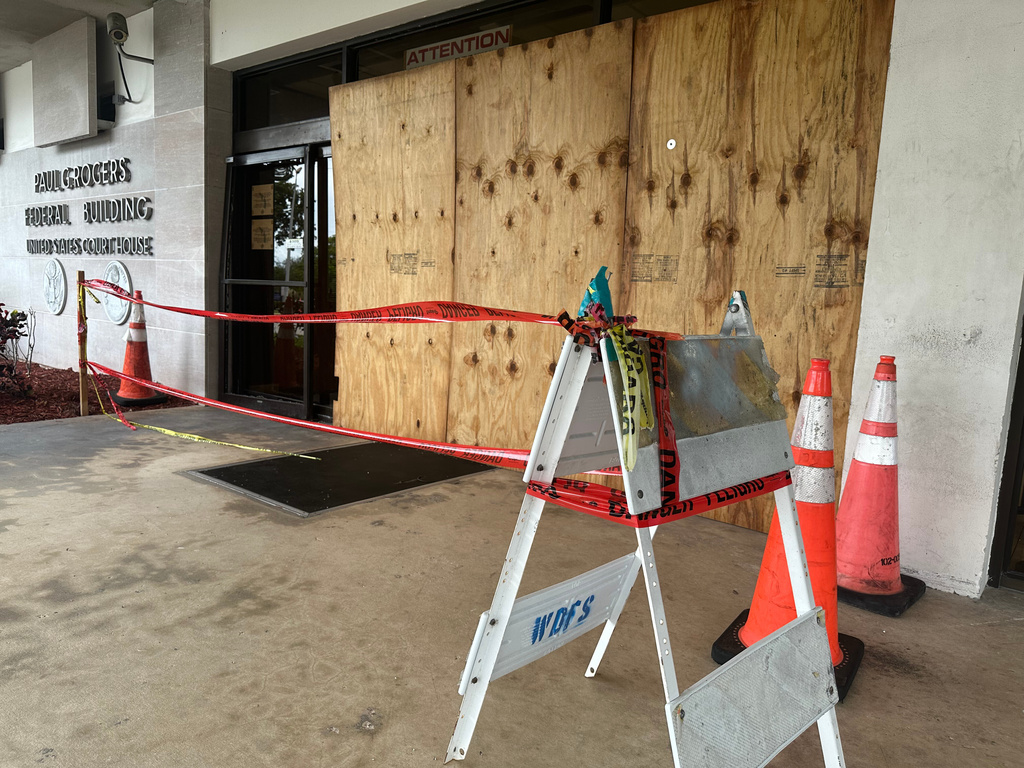 Damage is covered by plywood at the front entrance of Paul G. Rogers Federal Building in West Palm Beach, Fla. on Thursday, January 15, 2026 after a woman drove her car into the building. (AP Photo/Cody Jackson)