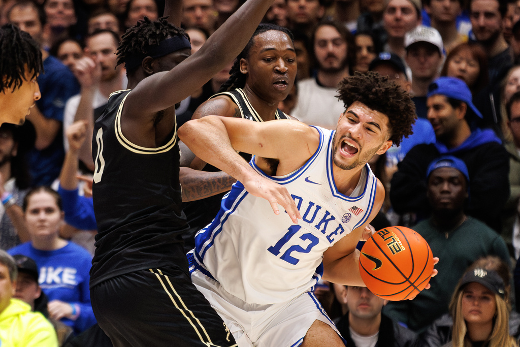 Duke's Cameron Boozer (12) handles the ball as Wake Forest's Omaha Biliew (0) and Tre'Von Spillers, center, defend during the first half of an NCAA college basketball game in Durham, N.C., Saturday, Jan. 24, 2026. (AP Photo/Ben McKeown)