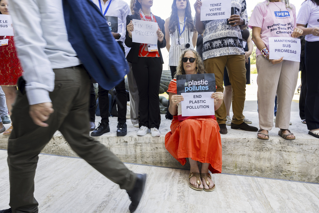 People protest with placards as delegates arrive prior to a session of the second part of the fifth session of the Intergovernmental Negotiating Committee on Plastic Pollution at the European headquarters of the United Nations in Geneva, Switzerland, Saturday, Aug. 9, 2025. (Salvatore Di Nolfi/Keystone via AP)