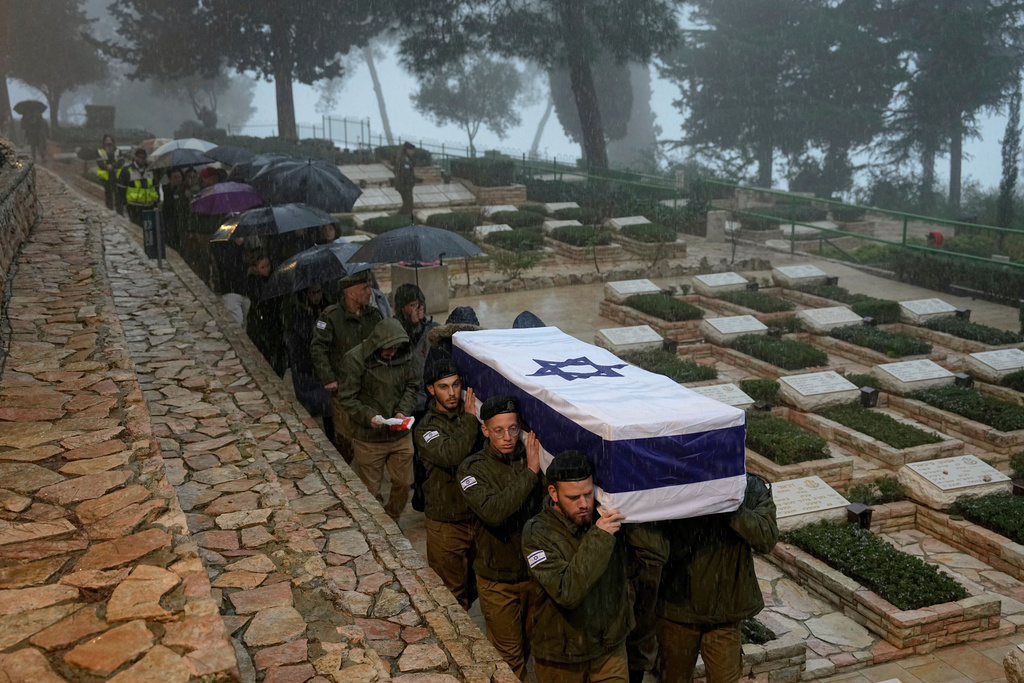 Israeli soldiers carry the flag-draped casket of reservist Elkana Vizel during his funeral at Mt. Herzl military cemetery in Jerusalem, Tuesday, Jan. 23, 2024. Vizel, 35, was killed during Israel's ground operation in the Gaza Strip. (AP Photo/Ohad Zwigenberg)