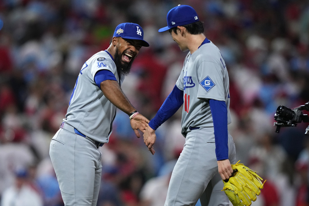 Los Angeles Dodgers' Teoscar Hernández, left, and Roki Sasaki celebrate after the Dodgers won Game 1 of baseball's National League Division Series against the Philadelphia Phillies, Saturday, Oct. 4, 2025, in Philadelphia. (AP Photo/Matt Slocum)