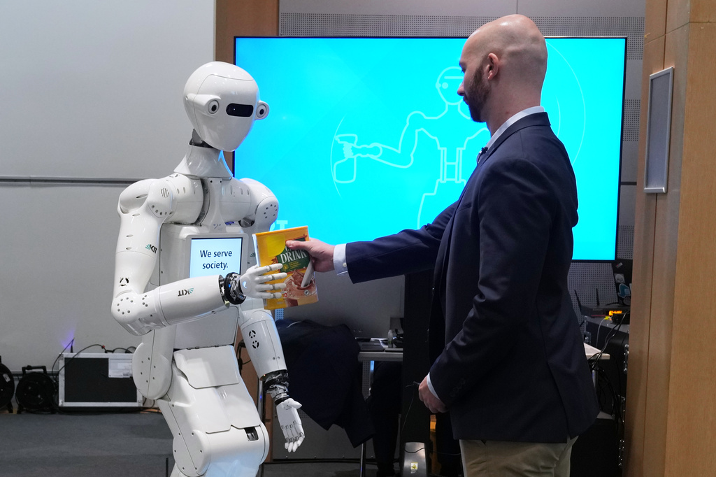 A man receives a box of chocolate powder drink from a robot during a demonstration of AI-based robotics in Europe at the European Parliament in Brussels, Wednesday, Sept. 2, 2026. (AP Photo/Virginia Mayo)