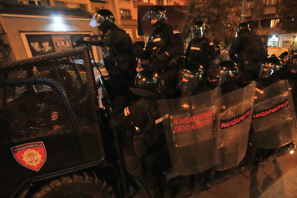 Serbian gendarmerie officers chase protesters during an anti-government protest in Belgrade, Serbia, Monday, Aug. 18, 2025. (AP Photo/Darko Vojinovic)