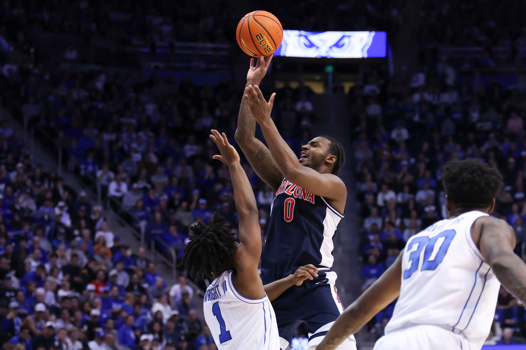 Arizona guard Jaden Bradley (0) goes up to shoot against BYU guard Robert Wright III (1) during the second half of an NCAA college basketball game, Monday, Jan. 26, 2026, in Provo, Utah. (AP Photo/Rob Gray)