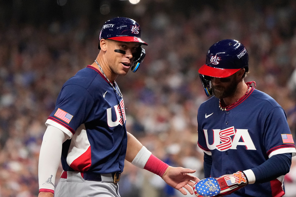 United States right fielder Aaron Judge, left, and first baseman Bryce Harper, right, celebrate as they score during the third inning of a World Baseball Classic quarterfinal game against Canada, Friday, March 13, 2026, in Houston. (AP Photo/David J. Phillip)