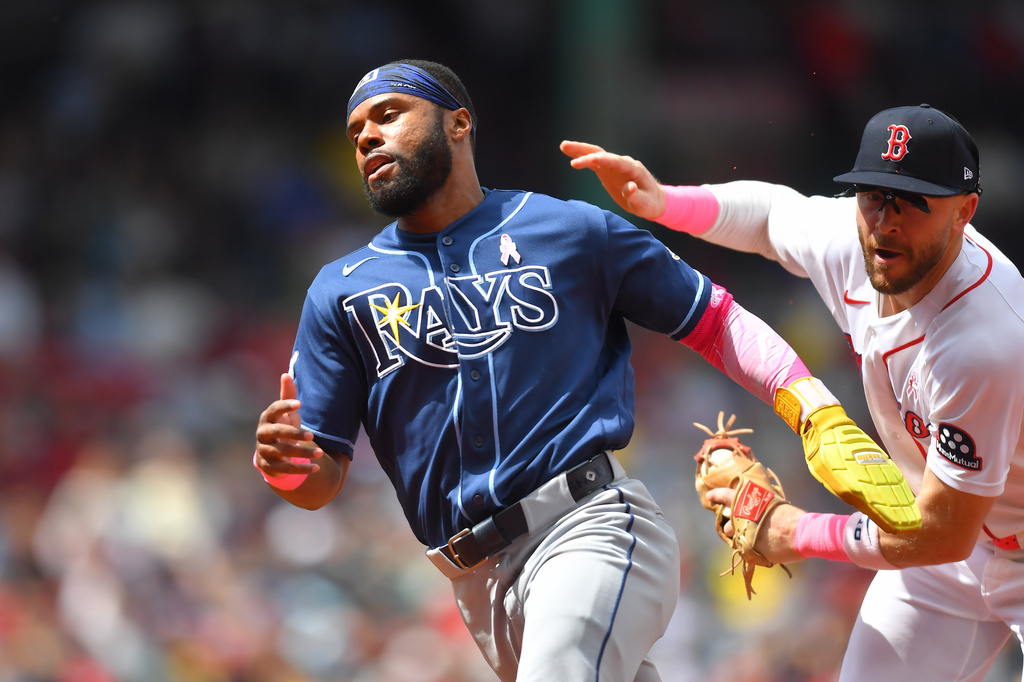Tampa Bay Rays' Cedric Mullins, left, tries to elude Boston Red Sox shortstop Trevor Story, right, before being tagged in a rundown in the fourth inning of a baseball game, Sunday, May 10, 2026, in Boston. (AP Photo/Steven Senne)