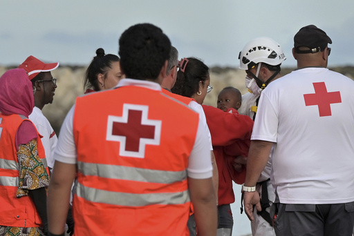A baby is carried by members of the Red Cross in the port of La Restinga at El Hierro in the Canary Islands on Saturday, June 6, 2024, after being rescued by the Spanish Sea Rescue. Spain's Canary Islands are struggling to deal with thousands of teenagers and children traveling alone to the archipelago from Senegal, Mali, and other African nations. (Europa Press via AP)