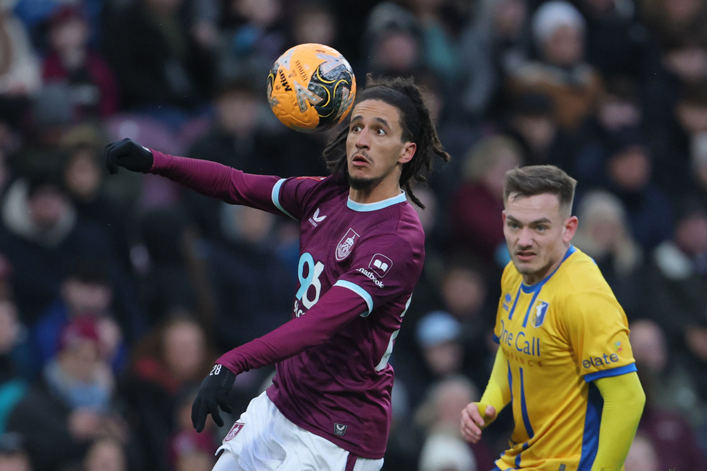 Burnley's Hannibal Mejbri, left, and Mansfield Town's Luke Bolton during the English FA Cup fourth round soccer match between Burnley and Mansfield Town in Burnley, England, Saturday Feb. 14, 2026. (Richard Sellers/PA via AP)