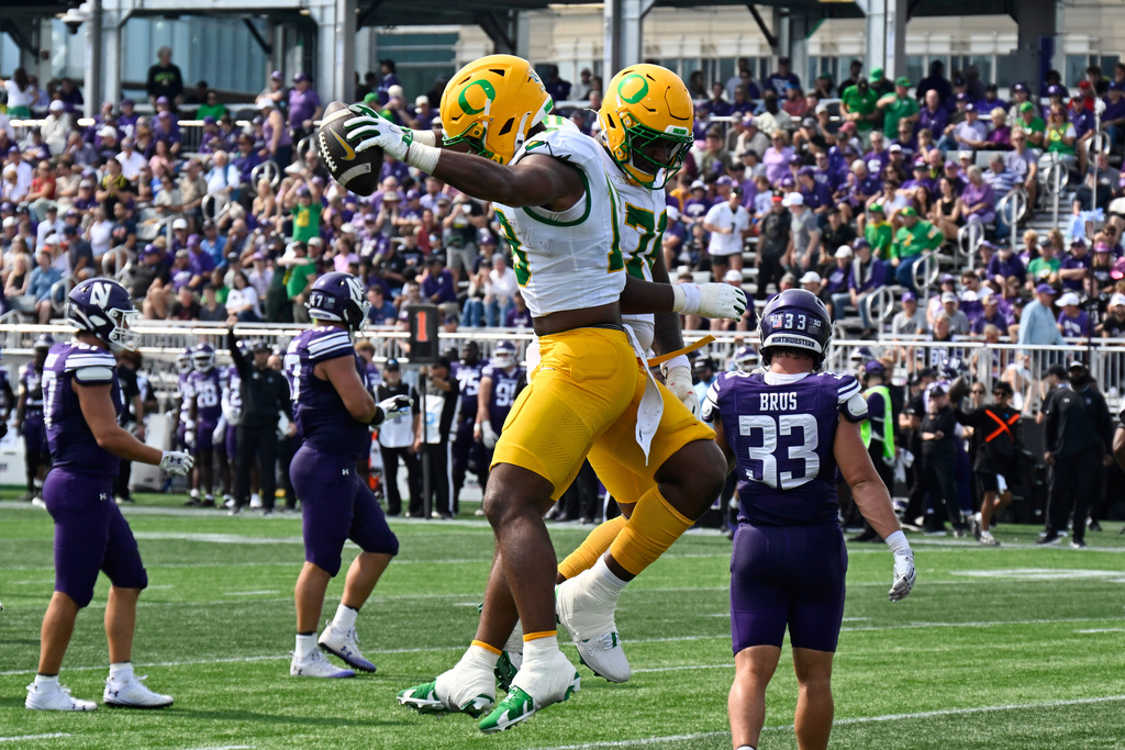 Oregon tight end Kenyon Sadiq (18), left, and offensive lineman Isaiah World (76) celebrate after Sadiq caught a touchdown pass against Northwestern during the first half of an NCAA college football game on Saturday, Sept. 13, 2025 in Evanston, Ill. (AP Photo/Matt Marton)