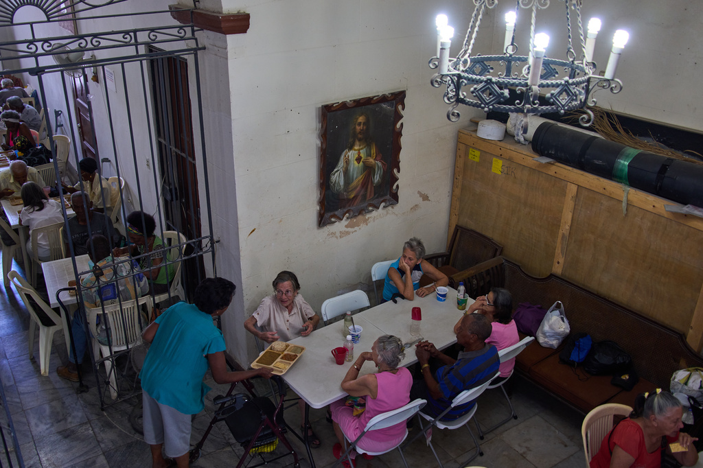 Carmen Casado, 84, is served a free meal of ground meat, rice, red beans and crackers through a program run by the Church of the Holy Spirit at a dining hall adjacent to the church in Old Havana, Cuba, Thursday, April 21, 2026. (AP Photo/Ramon Espinosa)