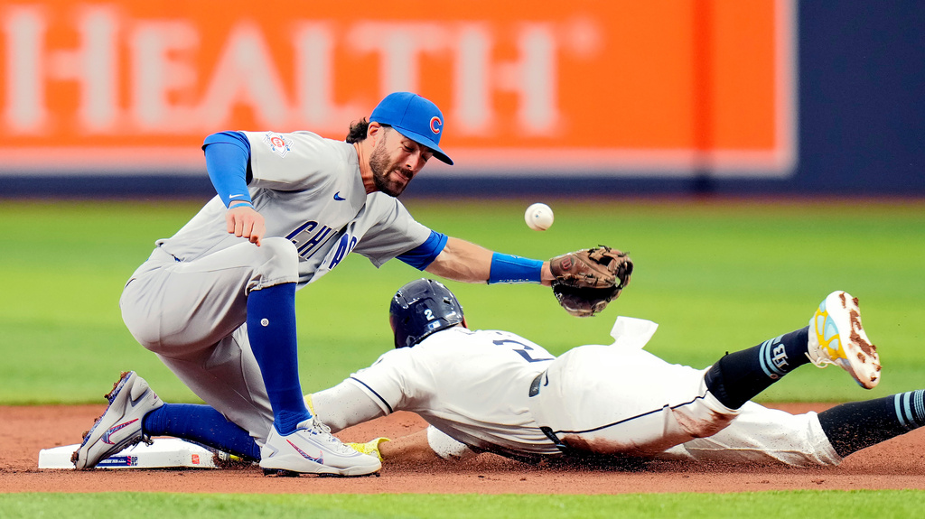 Tampa Bay Rays' Yandy Díaz (2) steals second base as Chicago Cubs shortstop Dansby Swanson (7) can't handle the throw during the first inning of a baseball game Monday, April 6, 2026, in St. Petersburg, Fla. (AP Photo/Chris O'Meara)