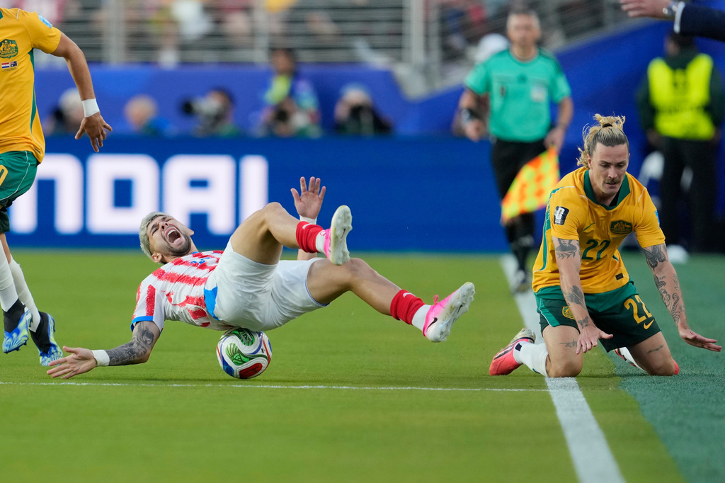 Paraguay's Julio Enciso (19) reacts after being tackled by Australia's Jackson Irvine (22) during the World Cup Group D soccer match between Paraguay and Australia in Santa Clara, Calif., near San Francisco, Thursday, June 25, 2026. (AP Photo/Eugene Hoshiko)