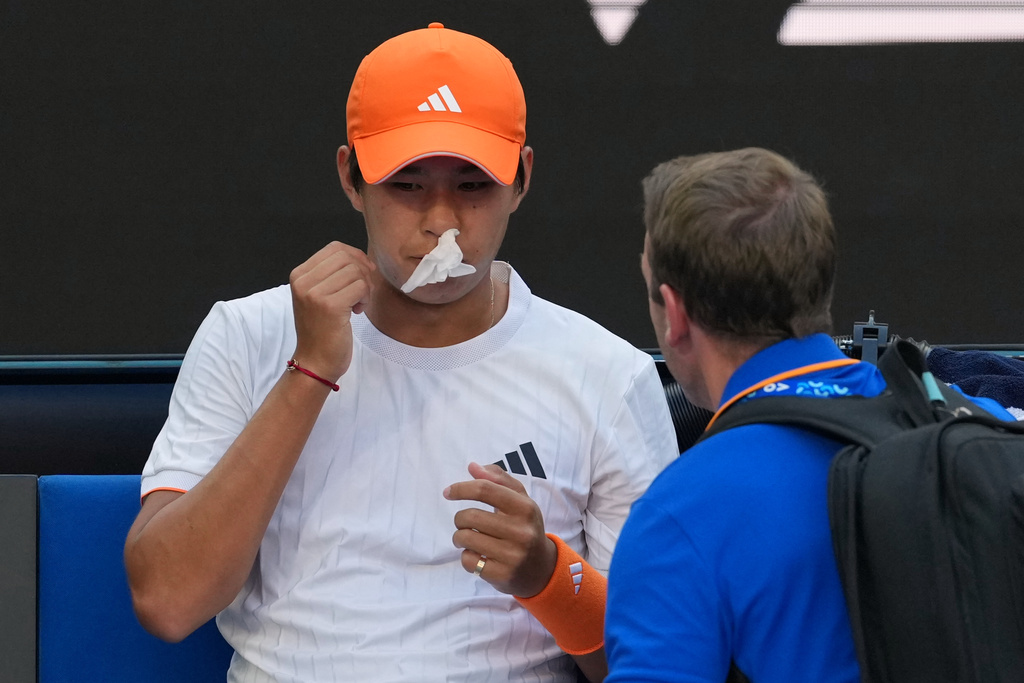Learner Tien of the U.S. receives treatment for a nose bleed during his fourth round match against Daniil Medvedev of Russia at the Australian Open tennis championship in Melbourne, Australia, Sunday, Jan. 25, 2026. (AP Photo/Asanka Brendon Ratnayake)