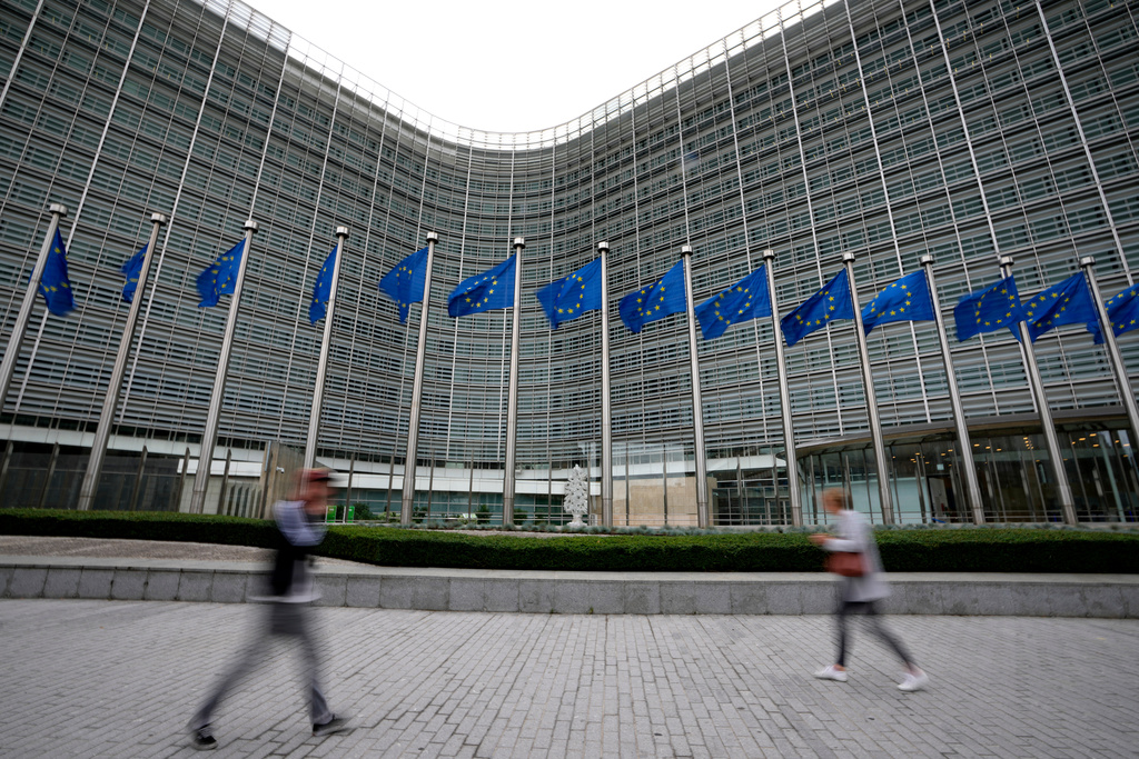 FILE - European Union flags flap in the wind as pedestrians walk by EU headquarters in Brussels, Wednesday, Sept. 20, 2023. (AP Photo/Virginia Mayo, File)
