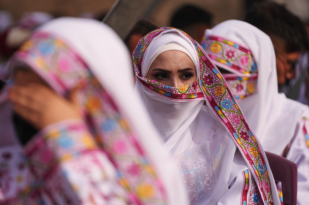 A Palestinian bride looks on as she gets married in a mass wedding ceremony in Deir al-Balah, central Gaza Strip, Friday, April 24, 2026. (AP Photo/Abdel Kareem Hana)