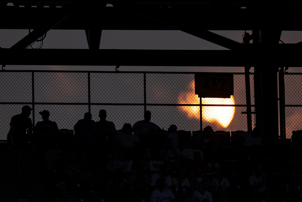 The Sun sets behind the stands during the fourth inning of a baseball game between the New York Mets and the Philadelphia Phillies, Thursday, July 16, 2026, in Philadelphia. (AP Photo/Chris Szagola)