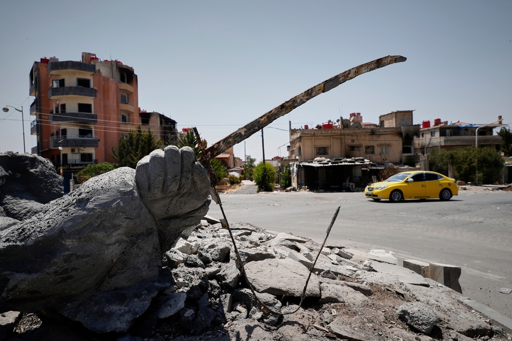 FILE - A car drives by a destroyed statue in the Druze-majority town of Sweida, Syria, Friday, July 25, 2025. (AP Photo/Omar Sanadiki, File)