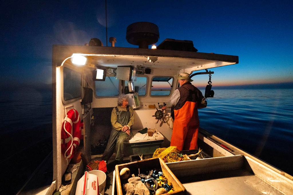 FILE - Virginia Oliver, 101, left, talks with her son, Max Oliver, while heading out to sea to catch lobsters at dawn, Aug. 31, 2021, off Rockland, Maine. (AP Photo/Robert F. Bukaty, File)