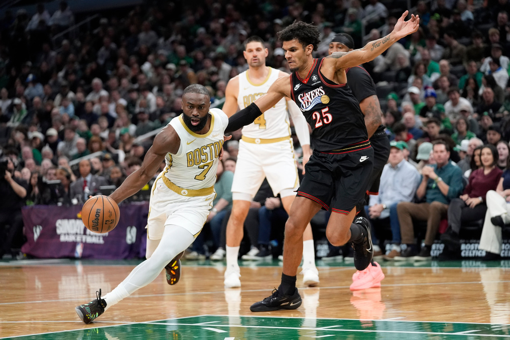 Boston Celtics guard Jaylen Brown (7) drives by Philadelphia 76ers forward Dominick Barlow (25) during the first half of an NBA basketball game, Sunday, March 1, 2026, in Boston. (AP Photo/Robert F. Bukaty)