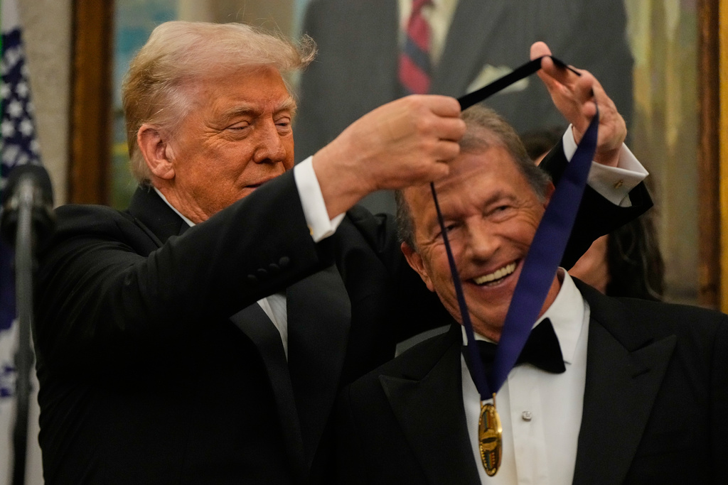 President Donald Trump, left, presents George Strait with his Kennedy Center Honors medal in the Oval Office of the White House, Saturday, Dec. 6, 2025, in Washington. (AP Photo/Julia Demaree Nikhinson)