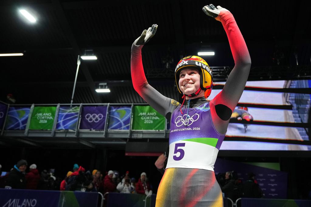 Germany's Merle Malou Fraebel waves as she arrives at the finish during a women's single luge run at the 2026 Winter Olympics, in Cortina d'Ampezzo, Italy, Monday, Feb. 9, 2026. (AP Photo/Alessandra Tarantino)