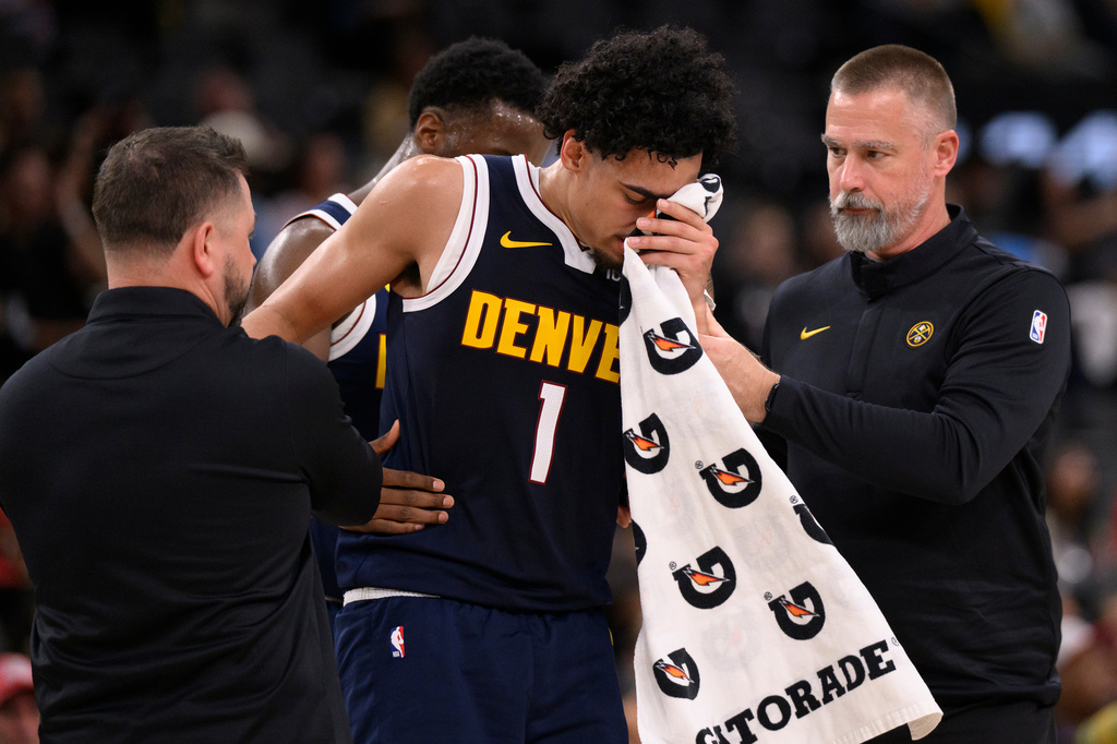 Denver Nuggets guard Julian Strawther (1) is assisted by staff members after he was injured during the second half of a preseason NBA basketball game against the Los Angeles Clippers Wednesday, Oct. 14, 2026, in Inglewood, Calif. (AP Photo/Kyusung Gong)