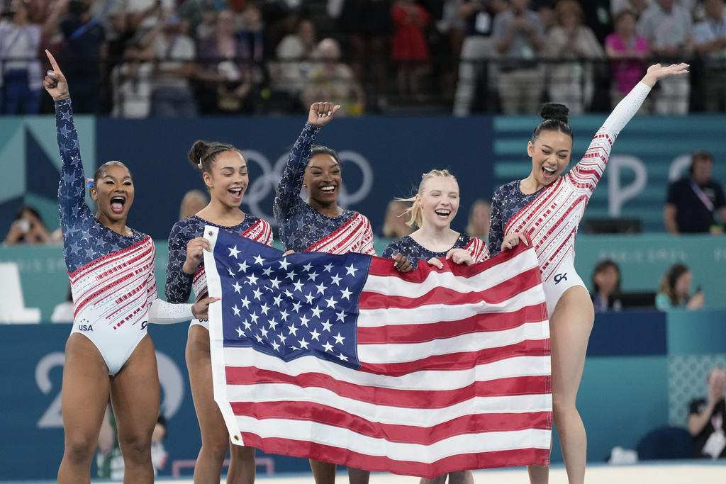 Members of Team USA celebrate after winning the gold medal in the women's artistic gymnastics team finals round at Bercy Arena at the 2024 Summer Olympics, Tuesday, July 30, 2024, in Paris, France. (AP Photo/Natacha Pisarenko)