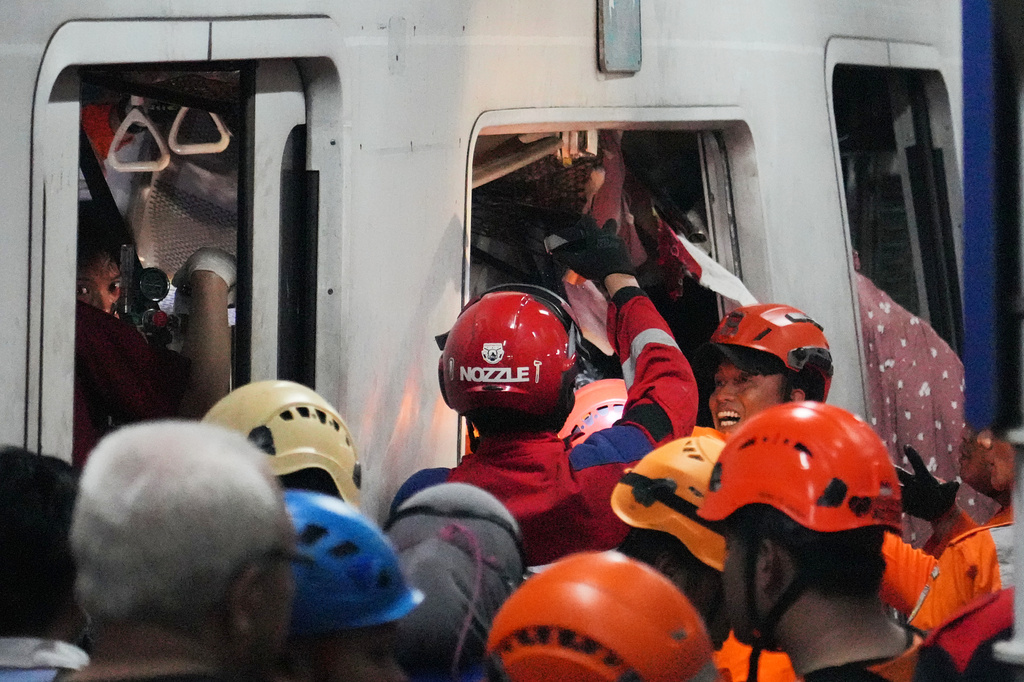 Rescuers search for victims after a train collision at a station in Bekasi, Indonesia, Monday, April 27, 2026. (AP Photo/Achmad Ibrahim)
