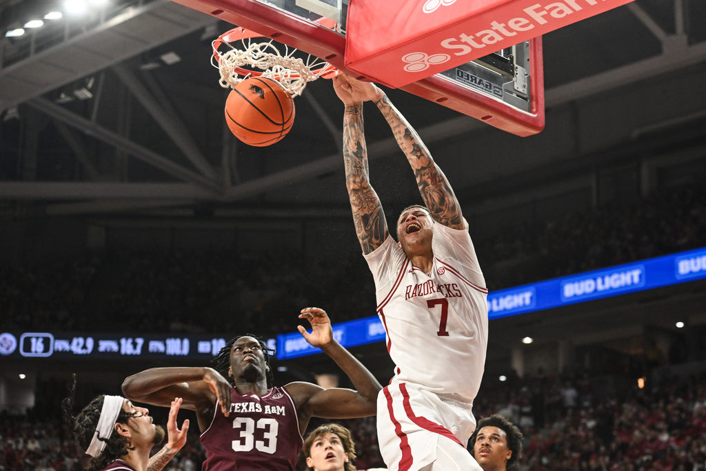Arkansas forward Trevon Brazile (7) dunks the ball over Texas A&M forward Federiko Federiko (33) during an NCAA college basketball game, Wednesday, Feb. 25, 2026, in Fayetteville, Ark. (AP Photo/Michael Woods)