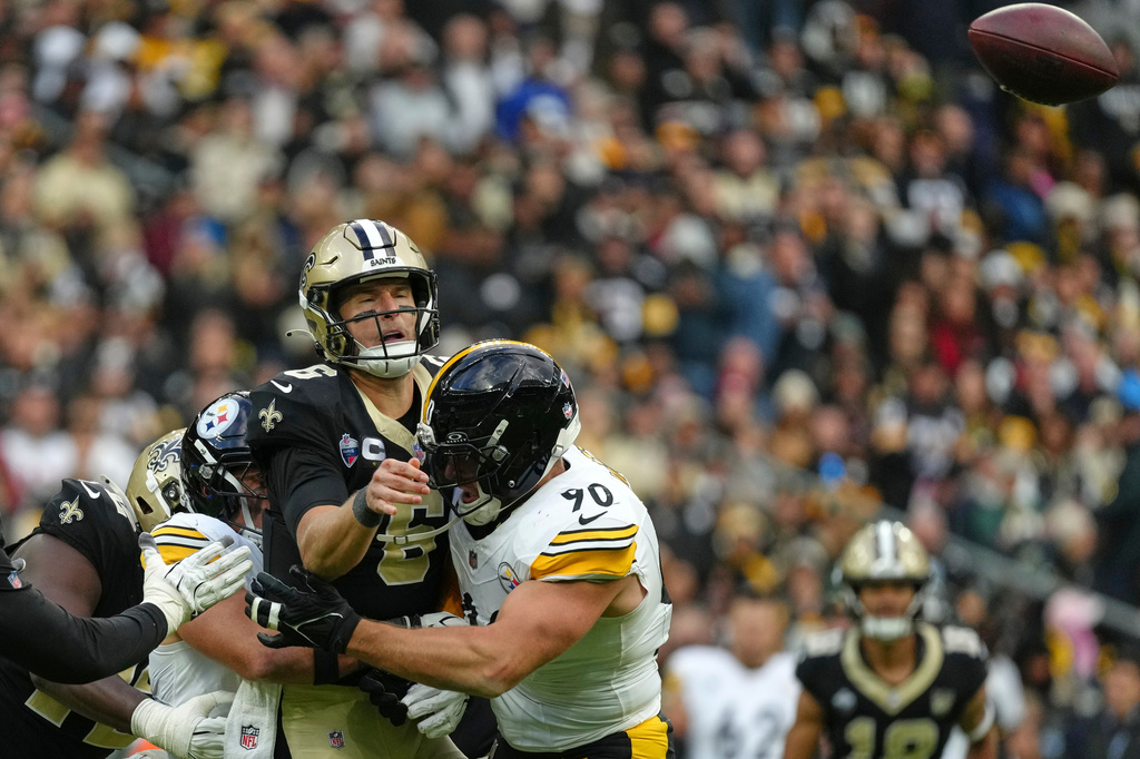New Orleans Saints quarterback Tyler Shough (6) is tackled by Pittsburgh Steelers linebacker T.J. Watt (90) during an NFL football game in Saint-Denis, outside Paris, Sunday, Oct. 25, 2026. (AP Photo/Aurelien Morissard)
