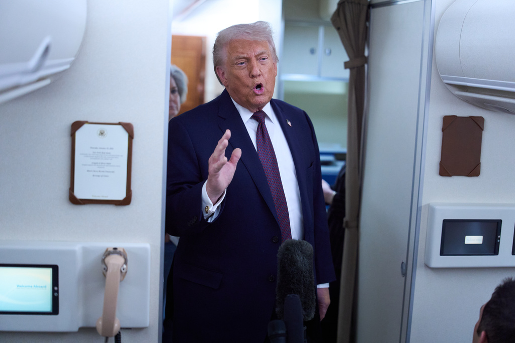 President Donald Trump speaks with reporters aboard Air Force One after leaving the World Economic Forum in Davos for Washington, Thursday, Jan. 22, 2026. (AP Photo/Evan Vucci)