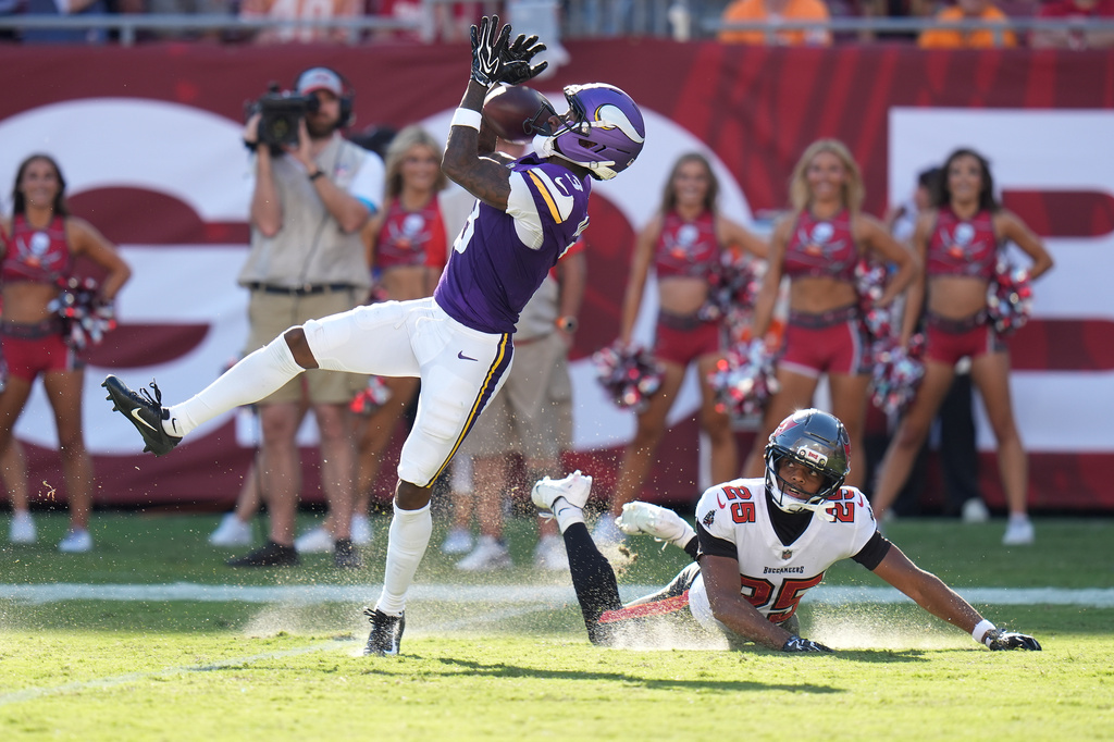 Minnesota Vikings wide receiver Jordan Addison (3) catches a pass for a touchdown as Tampa Bay Buccaneers cornerback Jacob Parrish (25) defends during the first half of an NFL football game in Tampa, Fla., Sunday, Sept. 27, 2026. (AP Photo/Chris O'Meara)