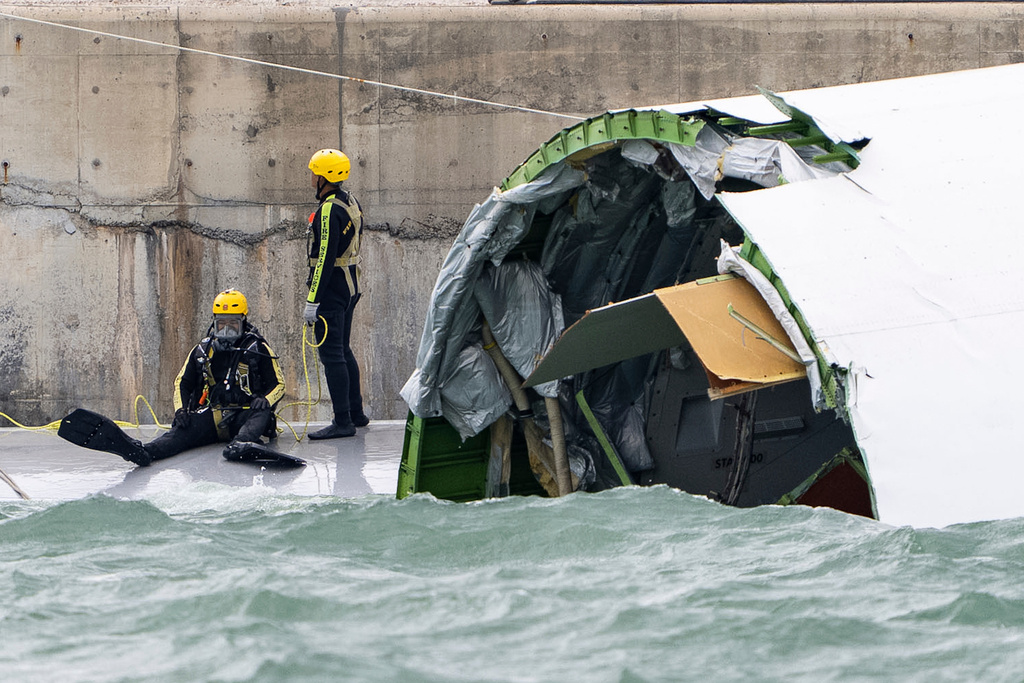 A diver prepares to inspect the cargo aircraft that skidded off a Hong Kong runway on Monday, Oct. 20, 2025. (AP Photo/Chan Long Hei)