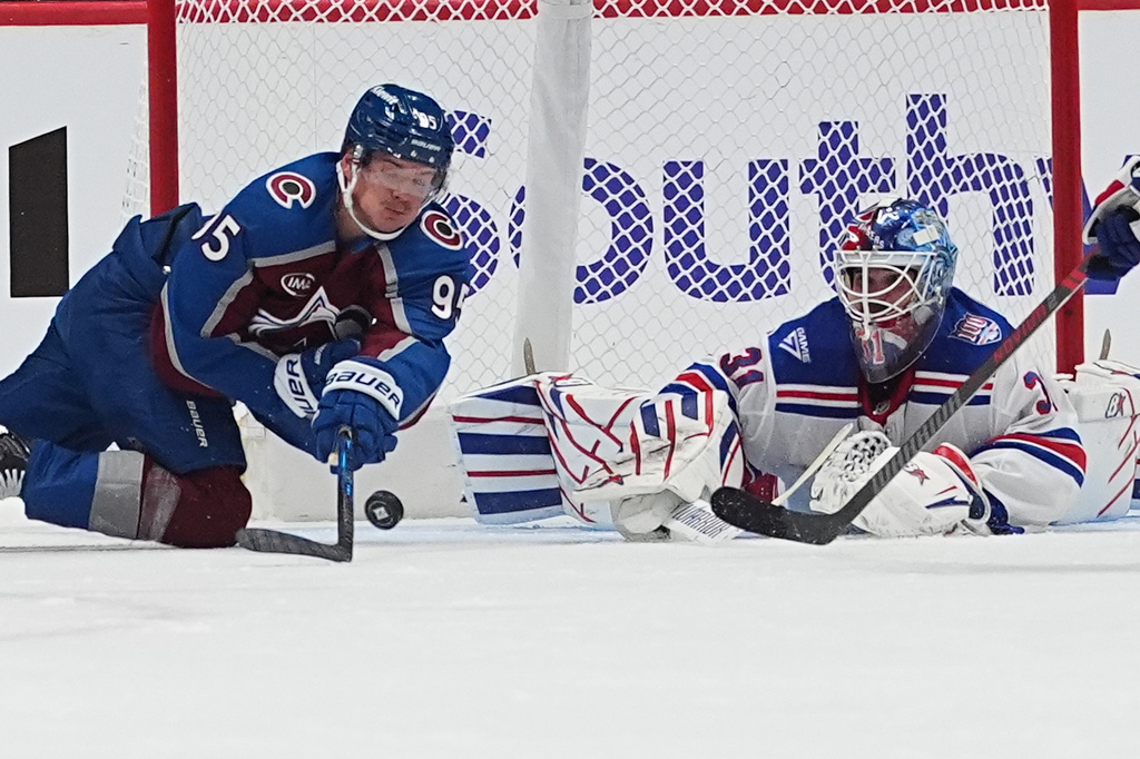 Colorado Avalanche left wing Victor Olofsson, left, tries to sweep the puck at New York Rangers goaltender Igor Shesterkin in the second period of an NHL hockey game Thursday, Nov. 20, 2025, in Denver. (AP Photo/David Zalubowski)