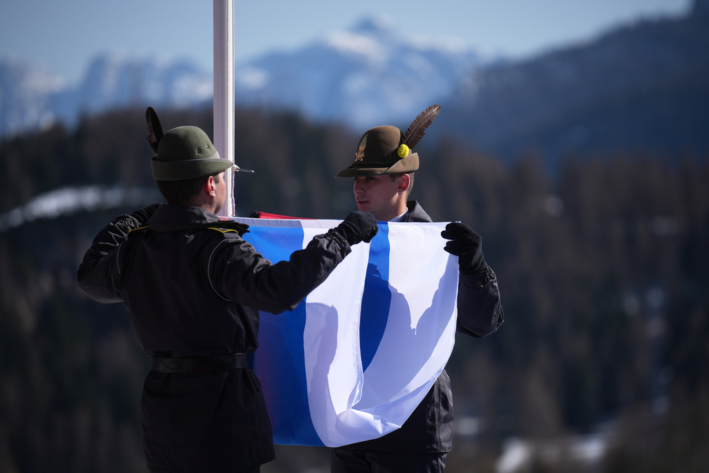 Italian soldiers fold the Russian flag after the medal ceremony for the alpine skiing men's downhill standing competition in which Aleksei Bugaev, of Russia, won the bronze medal, at the 2026 Winter Paralympics, in Cortina d'Ampezzo, Italy, Saturday, March 7, 2026. (AP Photo/Emilio Morenatti)