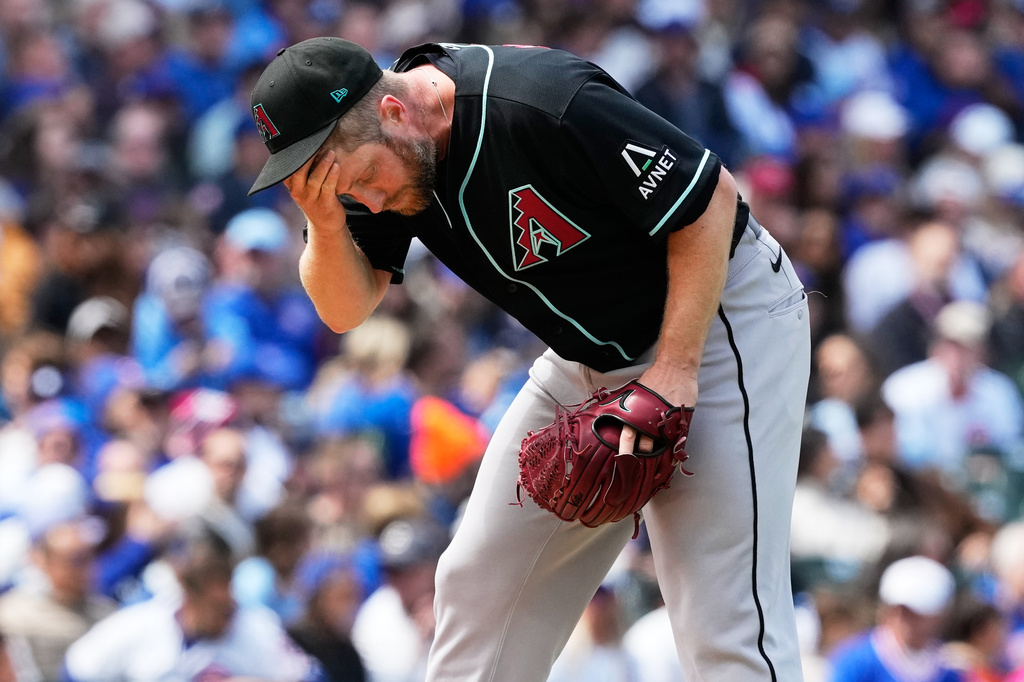 Arizona Diamondbacks starting pitcher Merrill Kelly reacts during the third inning of a baseball game against the Arizona Diamondbacks in Chicago, Sunday, May 3, 2026. (AP Photo/Nam Y. Huh)