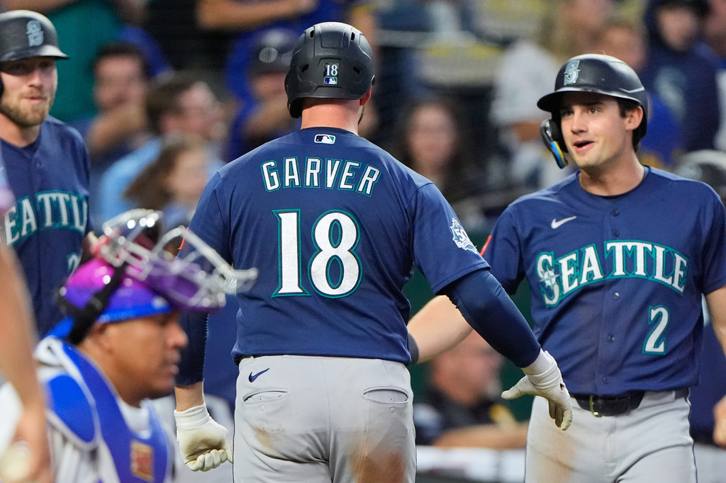 Seattle Mariners' Mitch Garver (18) celebrates with Cole Young (2) after hitting a two-run home run during the seventh inning of a baseball game against the Kansas City Royals, Friday, May 22, 2026, in Kansas City, Mo. (AP Photo/Charlie Riedel)