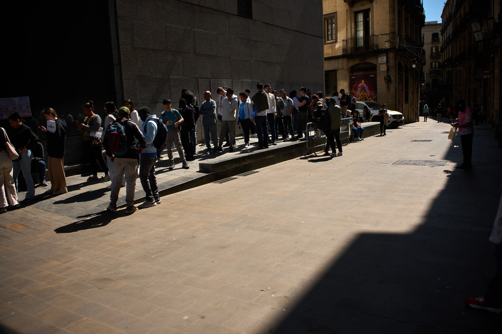 Migrants queue outside Barcelona City Hall to obtain paperwork needed to apply for Spain's immigration amnesty, which could allow hundreds of thousands of people to obtain legal status, in Barcelona, Spain, Monday, April 20, 2026. (AP Photo/Emilio Morenatti)