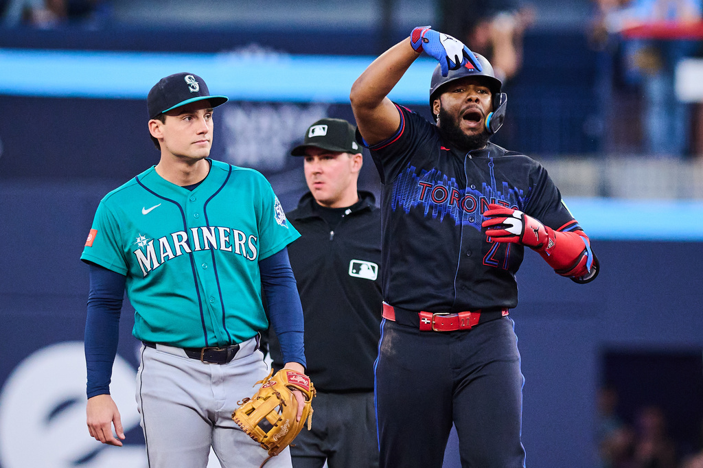 Toronto Blue Jays' Vladimir Guerrero Jr., right, celebrates after hitting an RBI double as Seattle Mariners second baseman Cole Young, left, looks on during the first inning of a baseball game in Toronto, Friday, Aug. 28, 2026. (Sammy Kogan/The Canadian Press via AP)