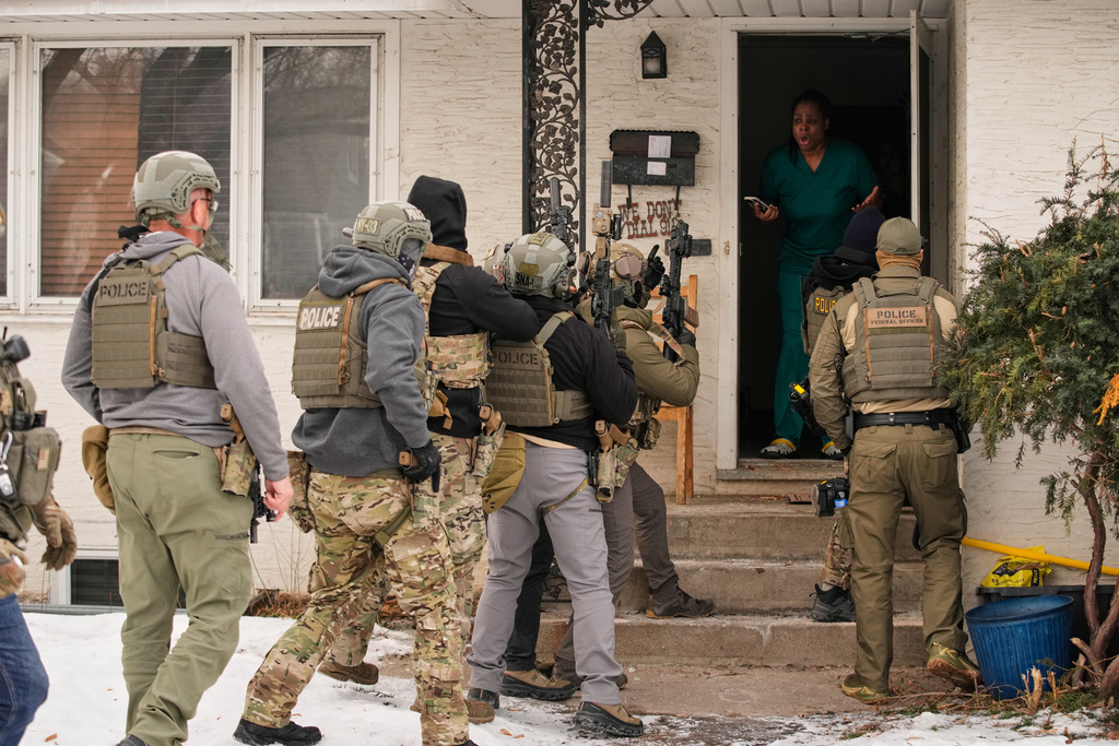FILE - Teyana Gibson Brown, standing in her doorway, wife of Garrison Gibson, reacts after a federal immigration officer used a battering ram to break down a door before arresting her husband, in Minneapolis, Jan. 11, 2026. (AP Photo/John Locher, File)