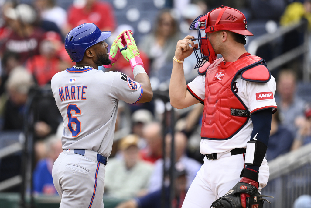 New York Mets' Starling Marte (6) celebrates after his home run next to Washington Nationals catcher Riley Adams, right, during the third inning of a baseball game, Thursday, Aug. 21, 2025, in Washington. (AP Photo/Nick Wass)