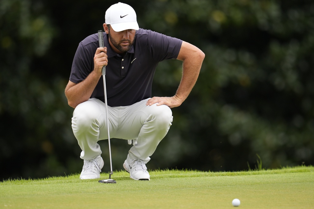 Scottie Scheffler lines up his putt on the second green during the third round of the Tour Championship golf tournament, Saturday, Aug. 23, 2025, in Atlanta. (AP Photo/Mike Stewart)