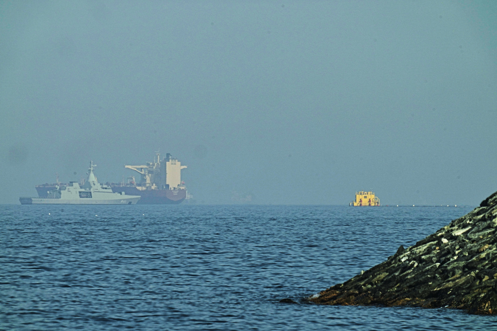 An Emirati patrol boat, left, is near a tanker anchored in the Gulf of Oman near the Strait of Hormuz, as seen from a coastal road near Khor Fakkan, United Arab Emirates, Friday, May 1, 2026. (AP Photo/Fatima Shbair)