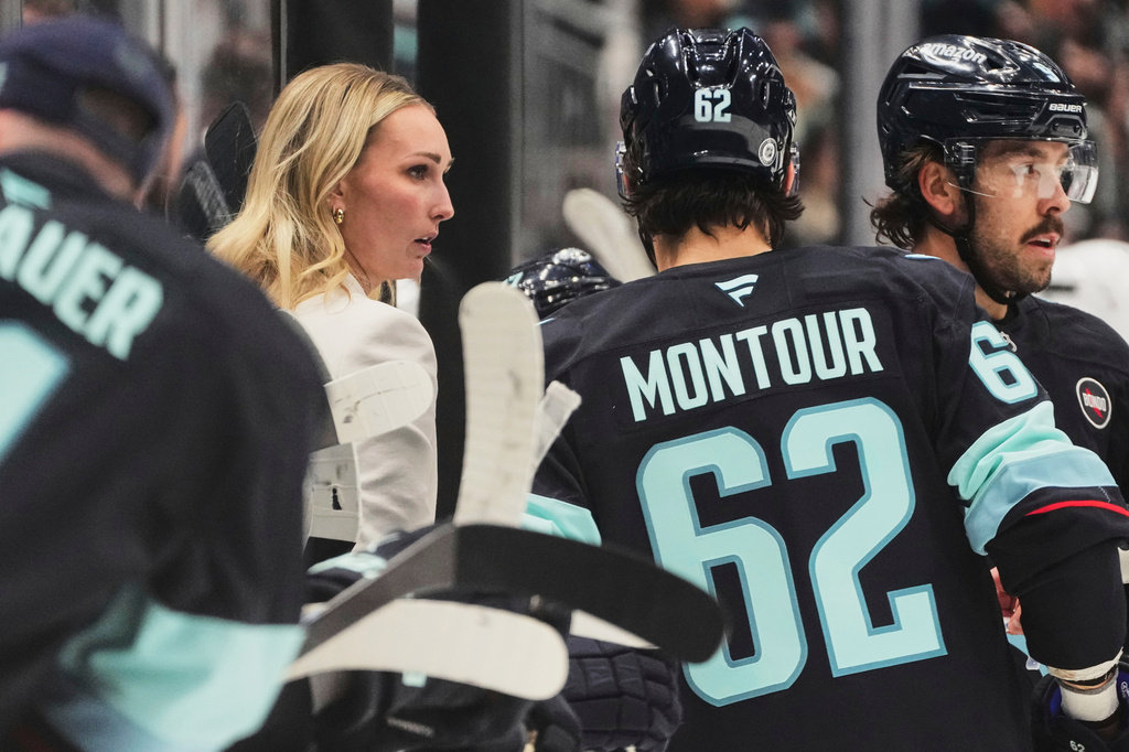 FILE - Seattle Kraken assistant coach Jessica Campbell talks with defenseman Brandon Montour (62) during a timeout in the third period of an NHL hockey game against the Los Angeles Kings, April 15, 2025, in Seattle. (AP Photo/Lindsey Wasson, File)
